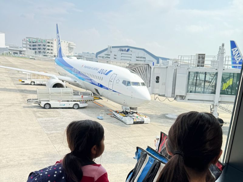 空港にて飛行機を眺める子供達